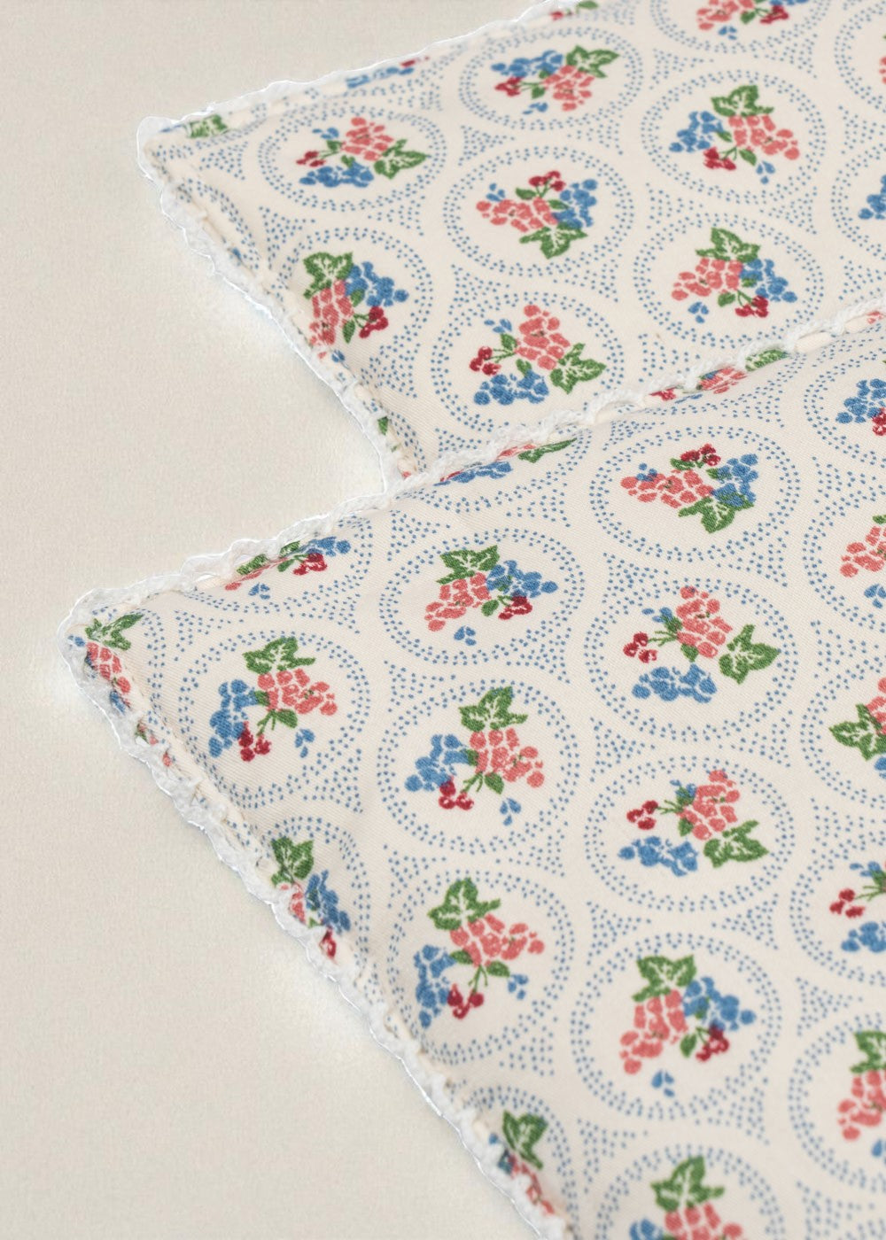 Close-up of Verona Blues print showing cornflower blue flowers with coral, cherry and green accents and dotted circle details