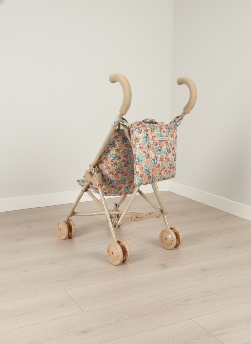 Floral-patterned baby buggy on a wooden floor with a white wall background