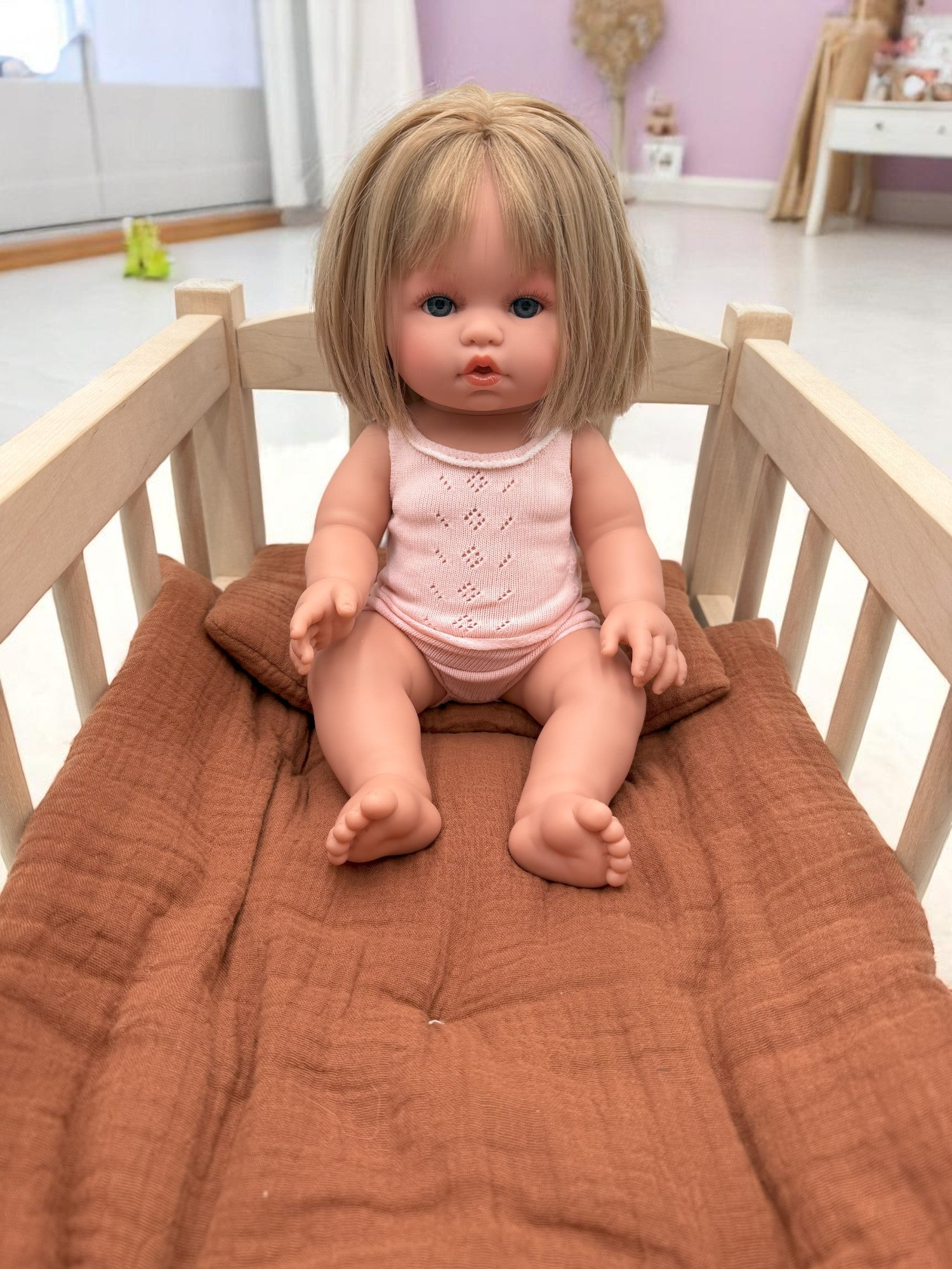 Realistic doll Vienna with silky blonde straight hair and pink pajamas for quality pretend play
