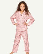 Child wearing Petite Plume Vintage Sweets pajamas featuring playful lollipop and candy pattern