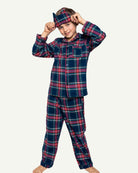 Child wearing Windsor Tartan pajamas in sophisticated navy plaid with coordinating sleep mask