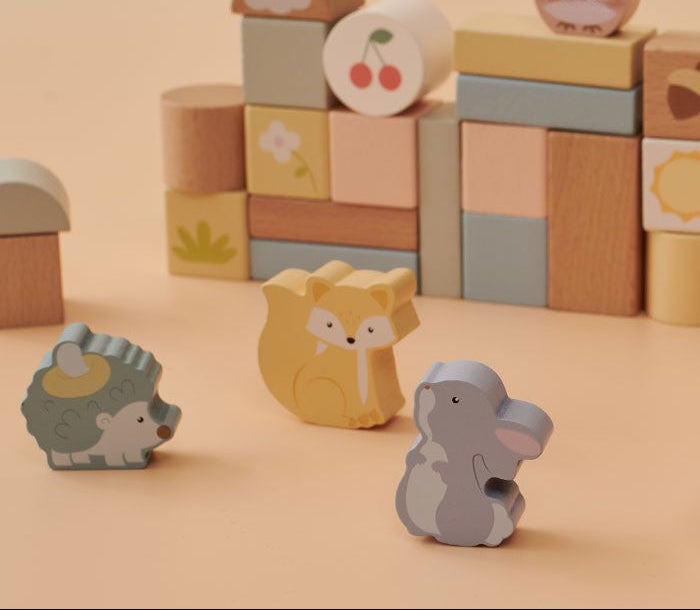 Close-up of woodland animal figures including deer, fox, bear, squirrel, hedgehog, and owl with hand-painted illustrations