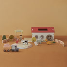Fiesta 25-piece wooden farmhouse playset displayed with barn, animals, farmer, truck, and puzzle mat on white background