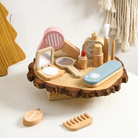 Wooden toy makeup set on a wooden base with various items including a mirror, brush, and bottles.