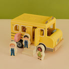 Fiesta wooden school bus playset with five diverse character figures and stop sign on neutral background