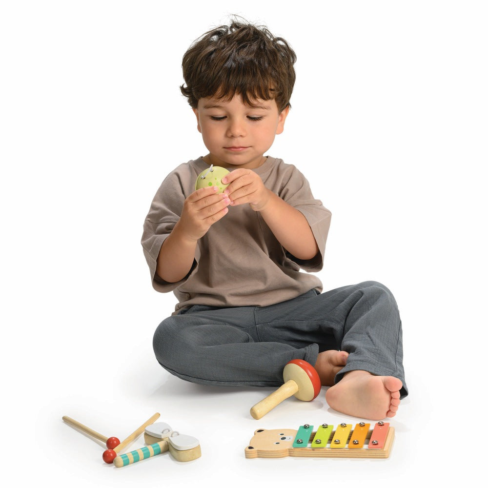 Child playing with Mentari bear xylophone and woodland percussion instruments