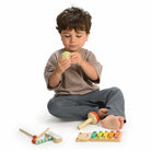 Child playing with Mentari bear xylophone and woodland percussion instruments