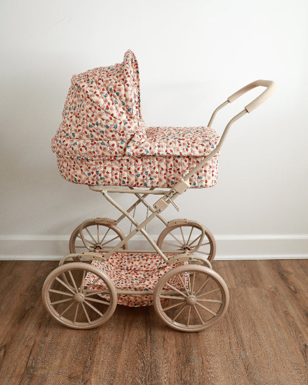 Marguerit berry vintage doll pram with cream quilted fabric and scattered wildflower daisy pattern on four large wheels