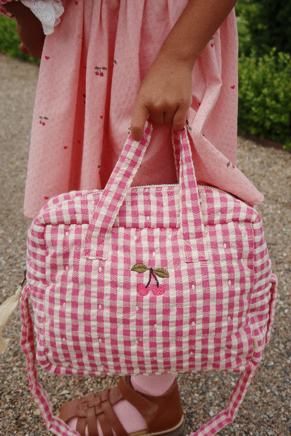 Bubblegum check pattern doll bag with coordinated hardware perfect for nurturing play