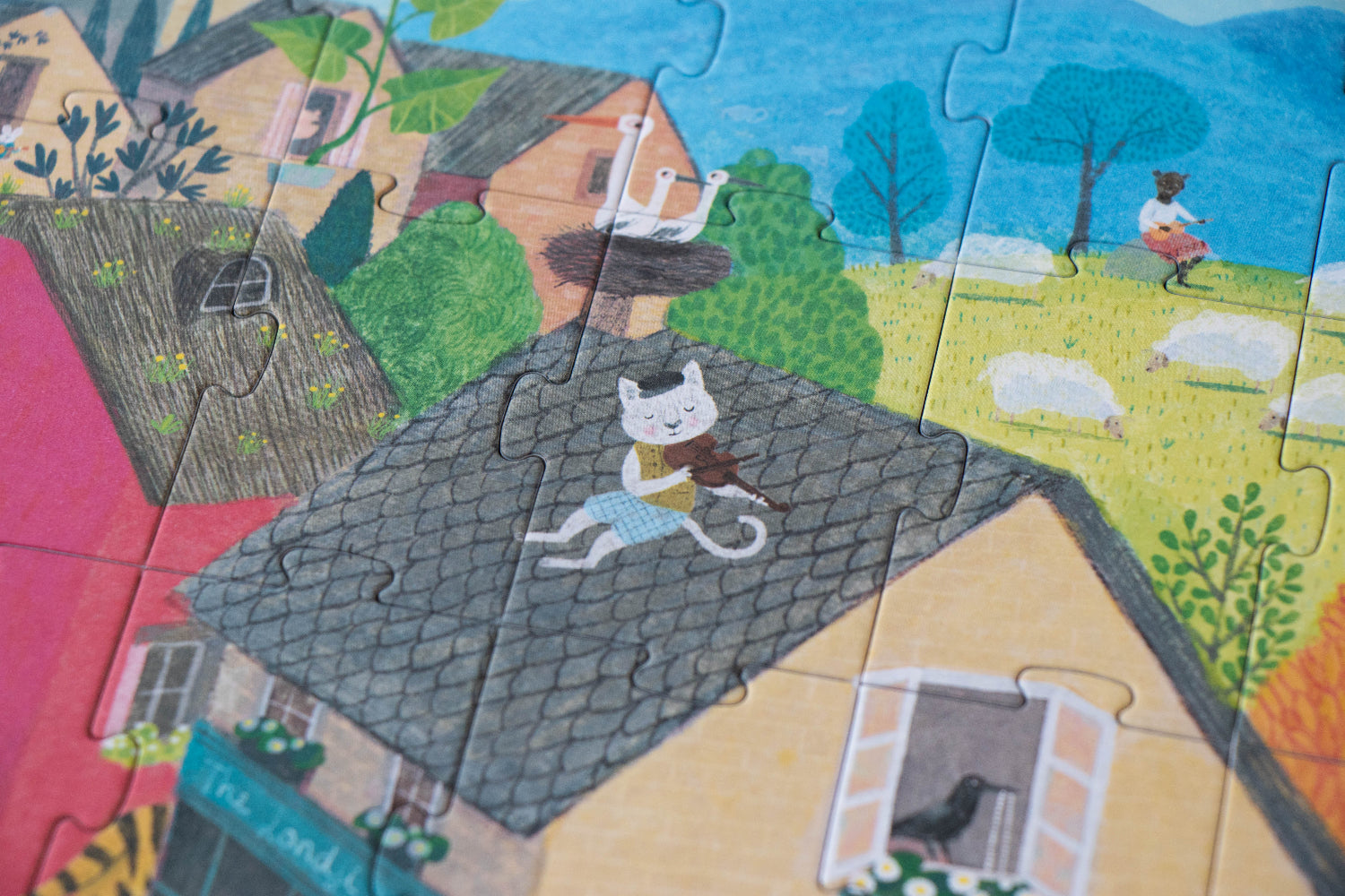 Children's puzzle with a cat on a roof and houses in the background