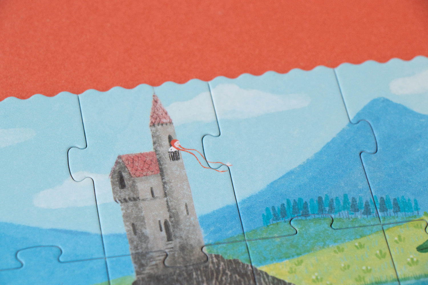 Jigsaw puzzle with a castle design on a red surface