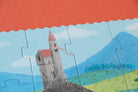 Jigsaw puzzle with a castle design on a red surface