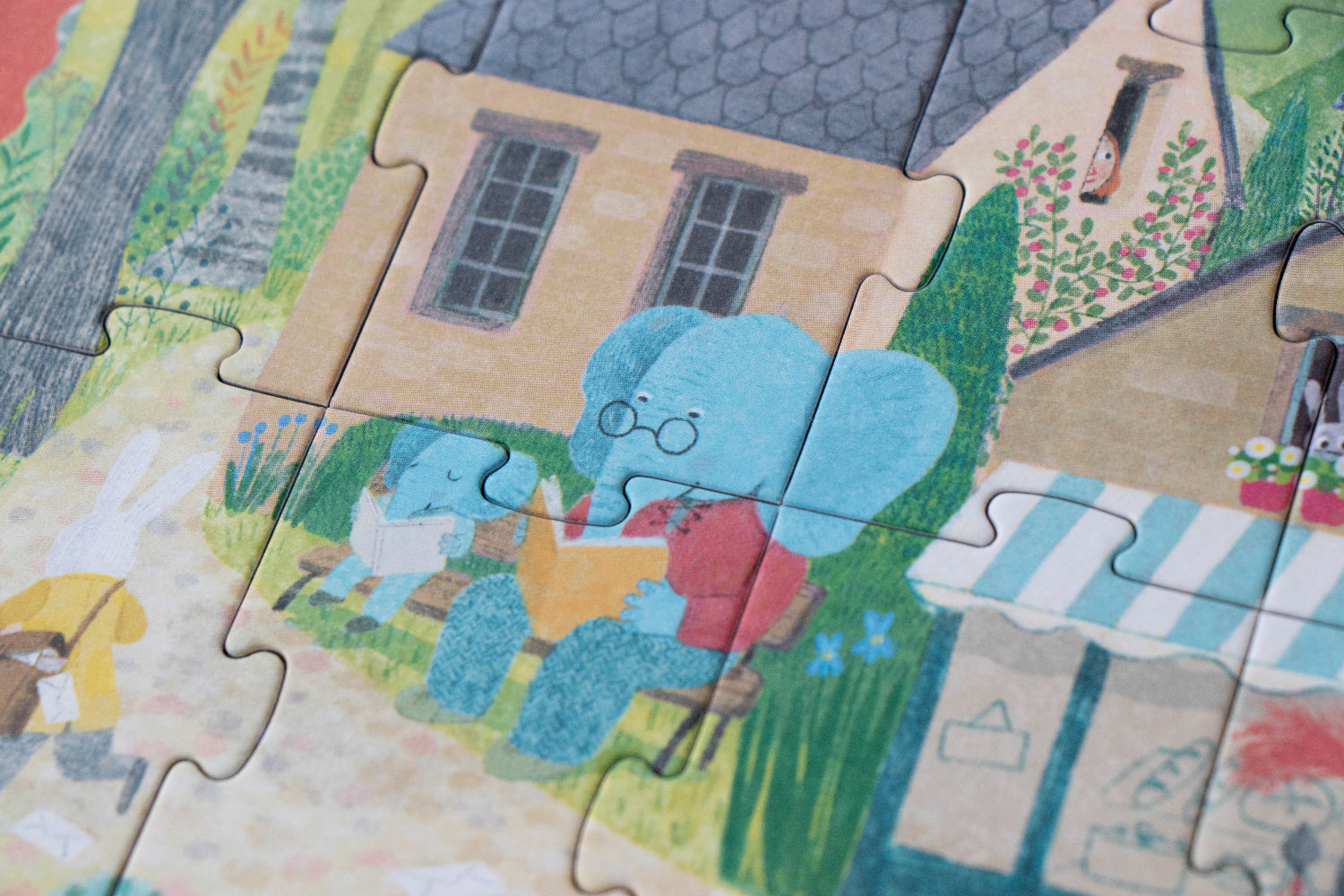 Children's puzzle with a cartoon elephant and bear in a garden setting
