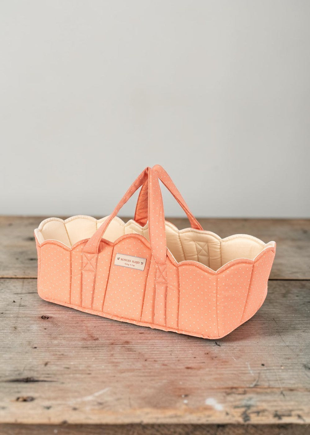 Playroom Collective Konges Sloejd quilted doll bassinet in coral with white dots and scalloped cream lining