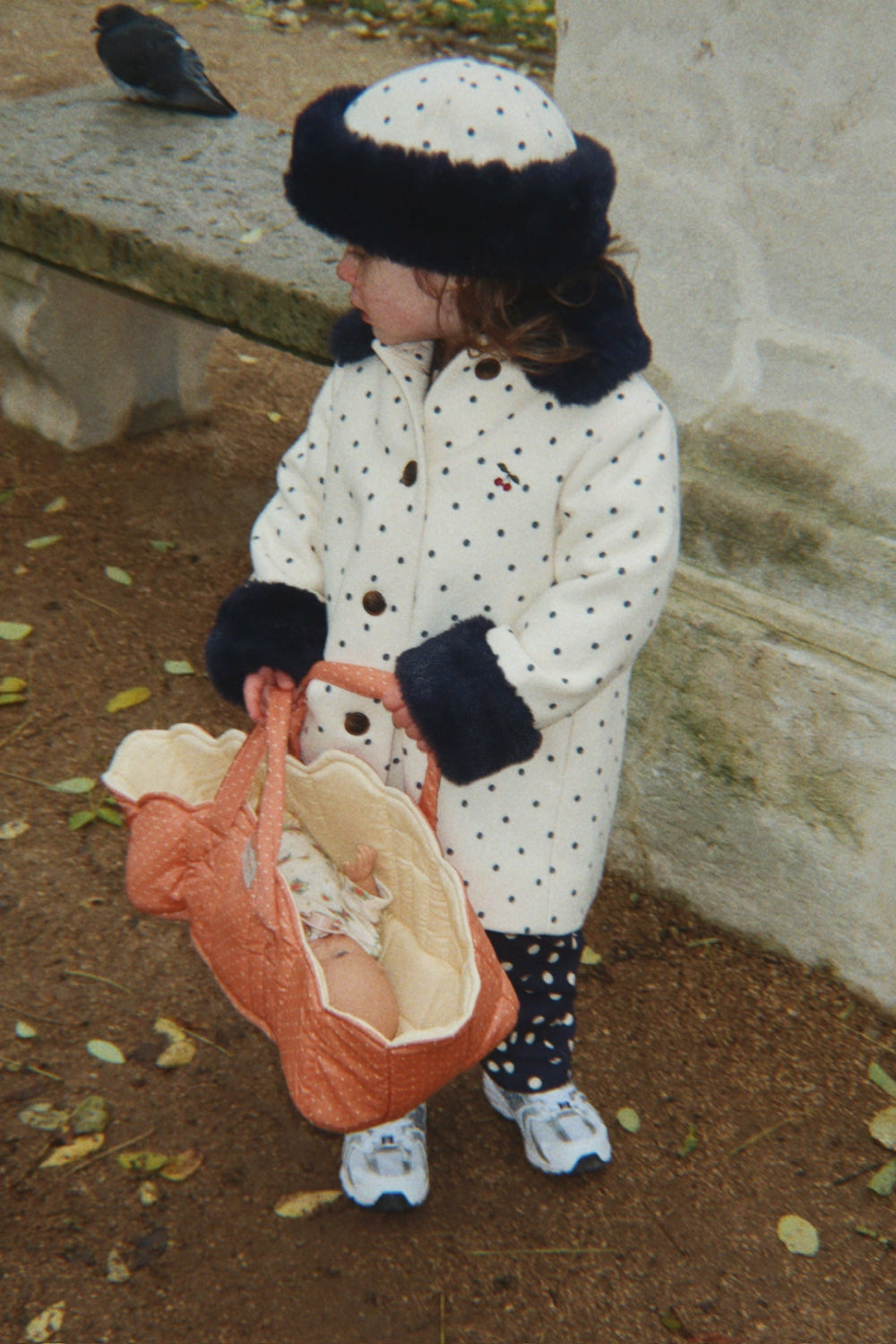 Child playing with Rose Dot Doll Bassinet
