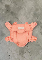 Playroom Collective Konges Sloejd baby doll carrier in coral pink with white dots and scalloped edge detail.