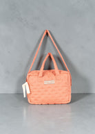 Playroom Collective Konges Sloejd doll diaper bag in coral cotton with white dot pattern and adjustable strap.
