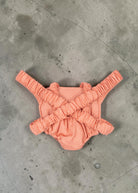 Playroom Collective Konges Sloejd doll carrier in rose coral cotton with white dots and flexible elastic straps.