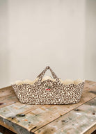 Playroom Collective quilted nursery storage basket in leopard print with scalloped edges and embroidered cherry detail