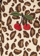Leopard print fabric with embroidered cherries on a beige background