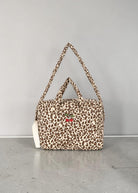 Playroom Collective Konges Sloejd leopard print cotton doll diaper bag with embroidered cherry detail and straps.