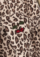 Playroom Collective Konges Sloejd doll stroller fabric featuring a cream and brown leopard print with cherry embroidery