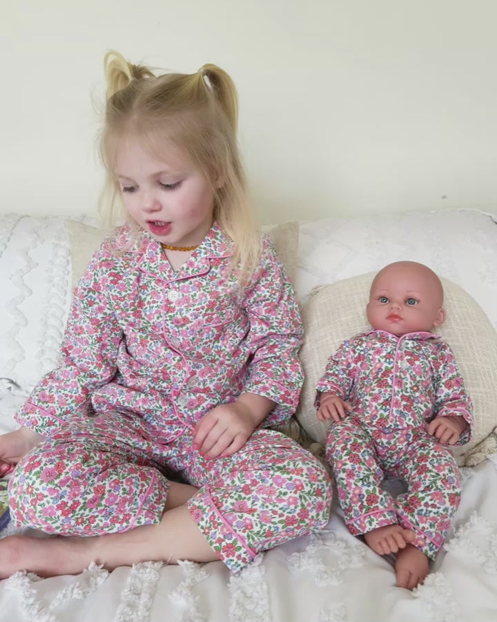 girl and doll playing in floral pajamas