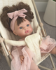 Child playing with doll in doll stroller and doll diaper bag.