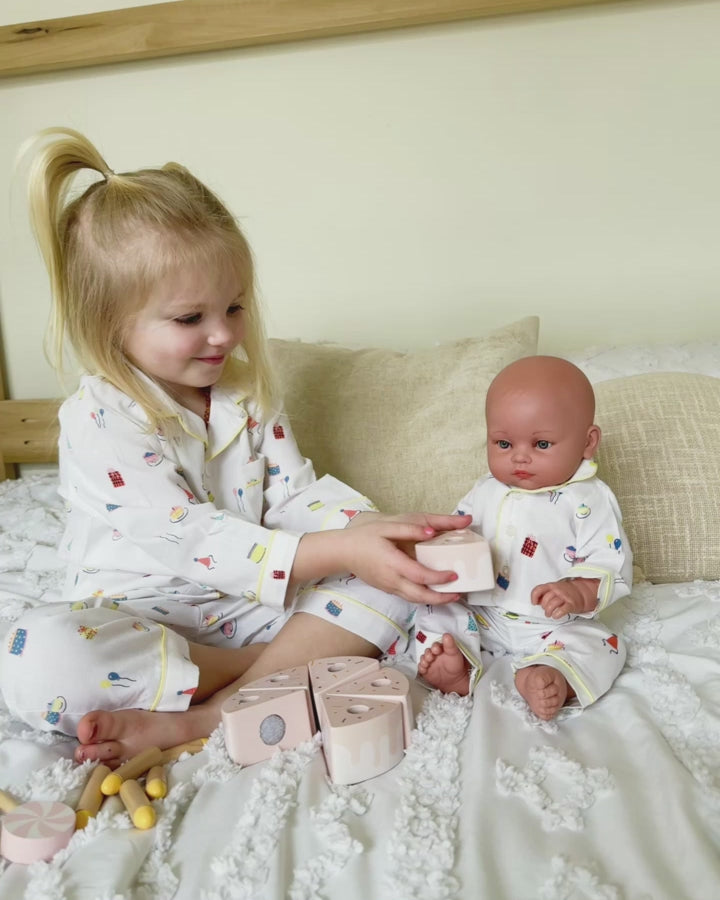 Girl and doll playing in birthday pajamas