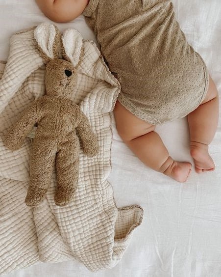 Child carrying Senger Naturwelt beige rabbit toy showing size and scale